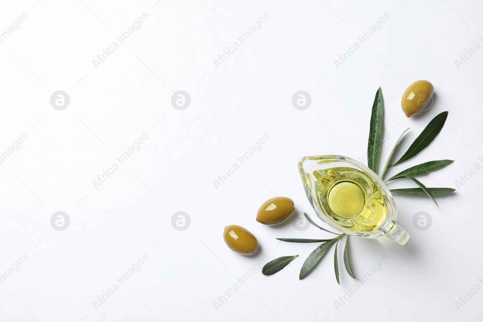 Photo of Gravy boat with oil and ripe olives on white background