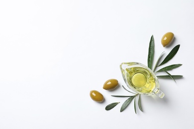 Gravy boat with oil and ripe olives on white background