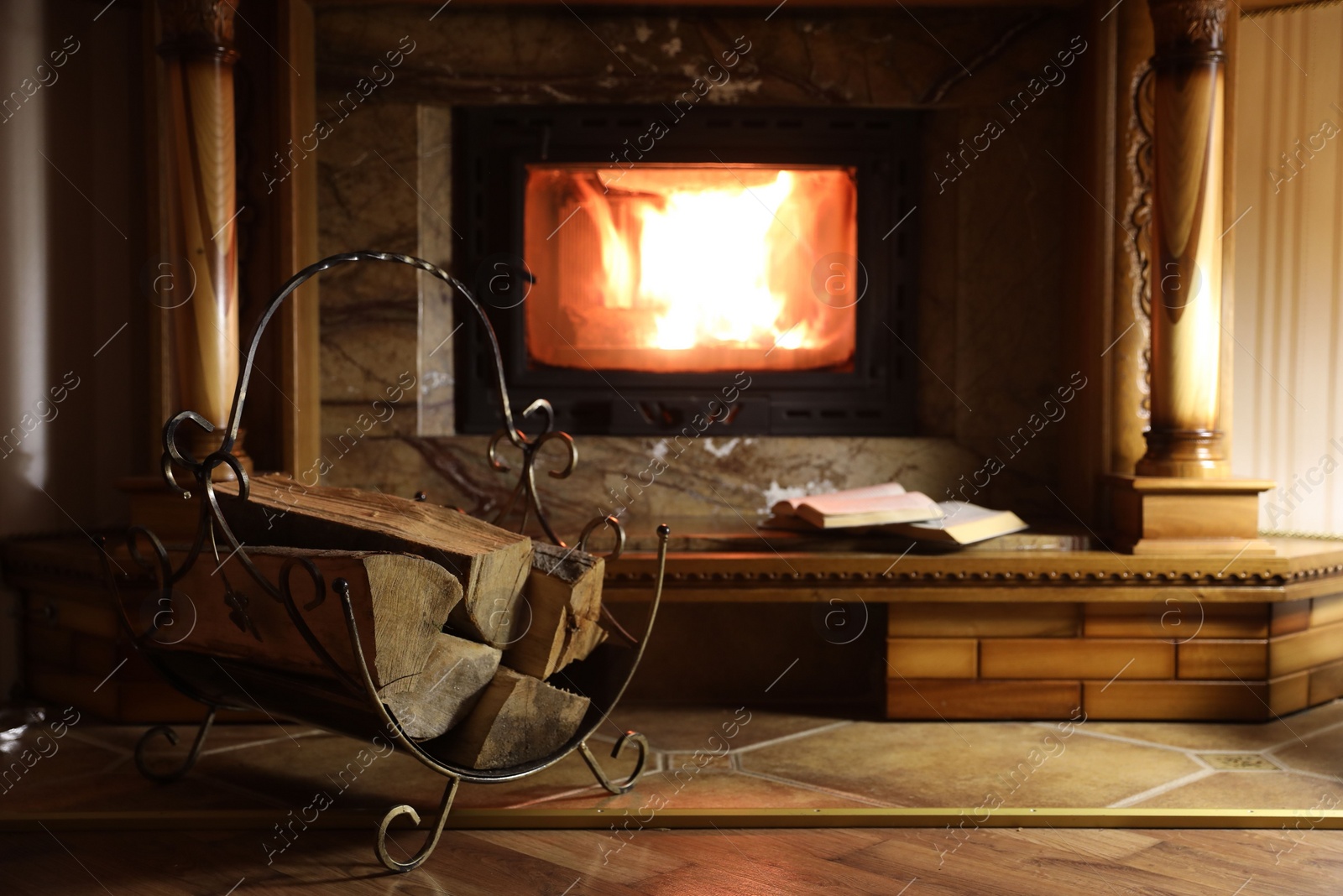 Photo of Books and firewood near fireplace at home