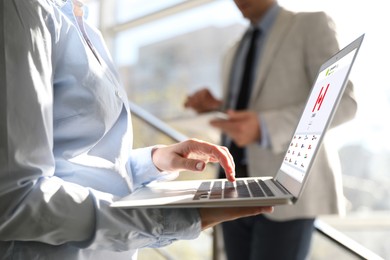 Image of Woman using modern laptop with switched on VPN in office, closeup