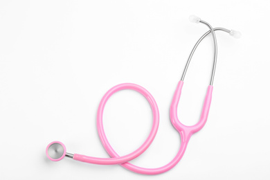 Photo of Pink stethoscope isolated on white, top view. Breast cancer awareness