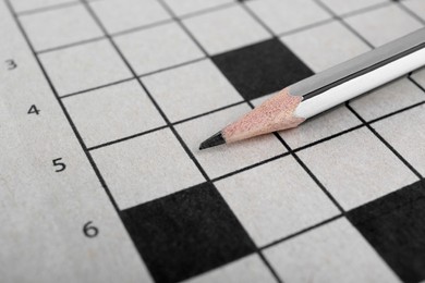 Pencil on blank crossword, closeup view. Space for text
