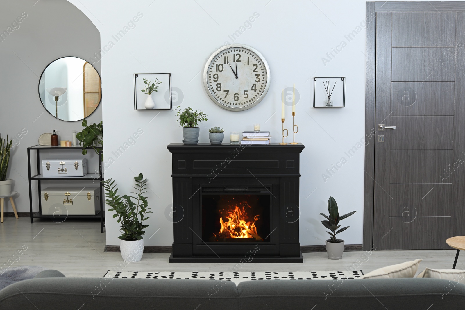 Photo of Stylish living room interior with fireplace and green plants