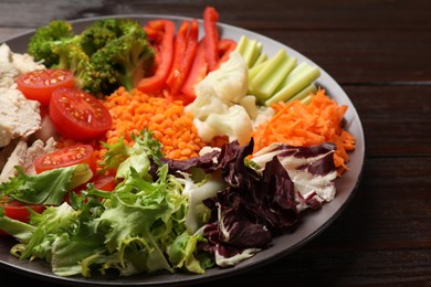 Balanced diet and healthy foods. Plate with different delicious products on dark wooden table, closeup