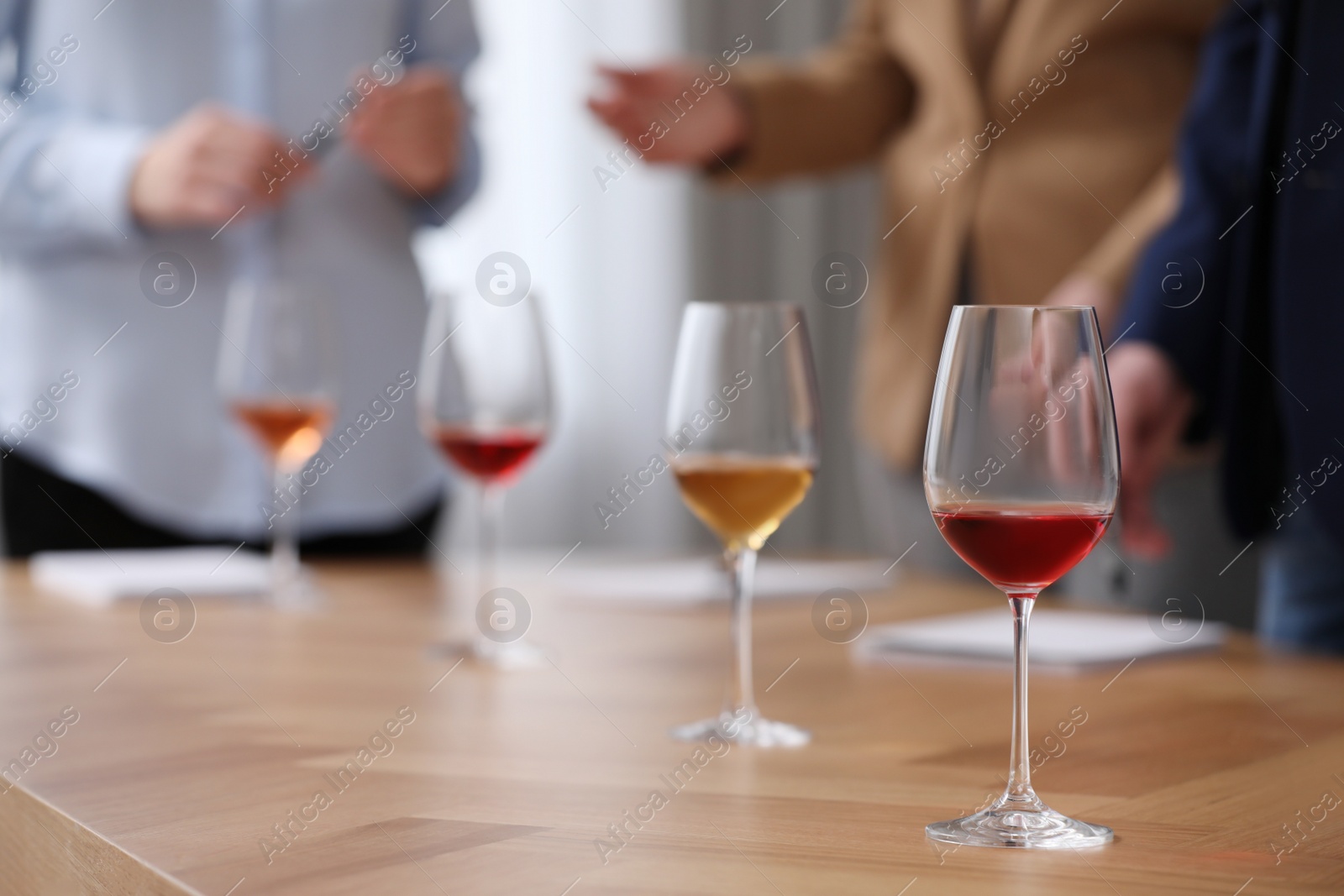 Photo of Sommeliers making notes during wine tasting at table indoors, closeup