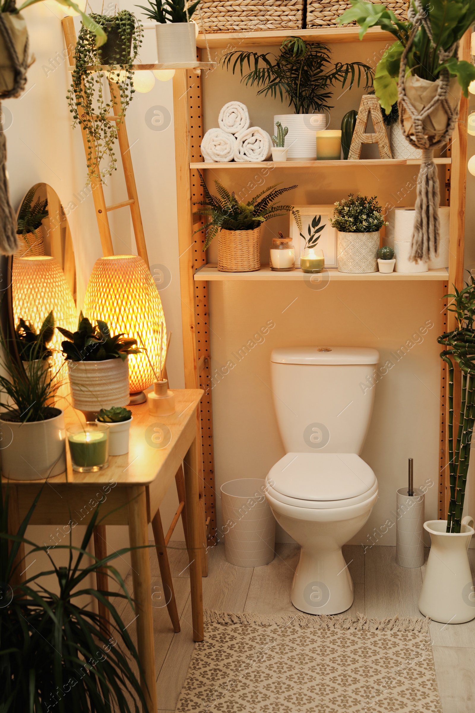 Photo of Stylish bathroom interior with toilet bowl and green plants