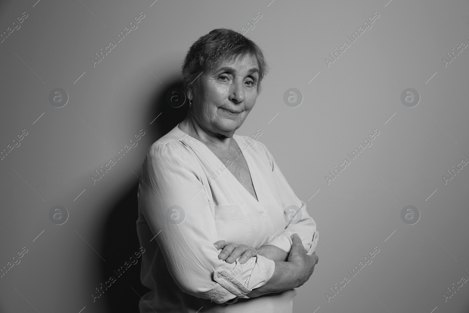 Photo of Portrait of elderly woman on grey background. Black and white effect