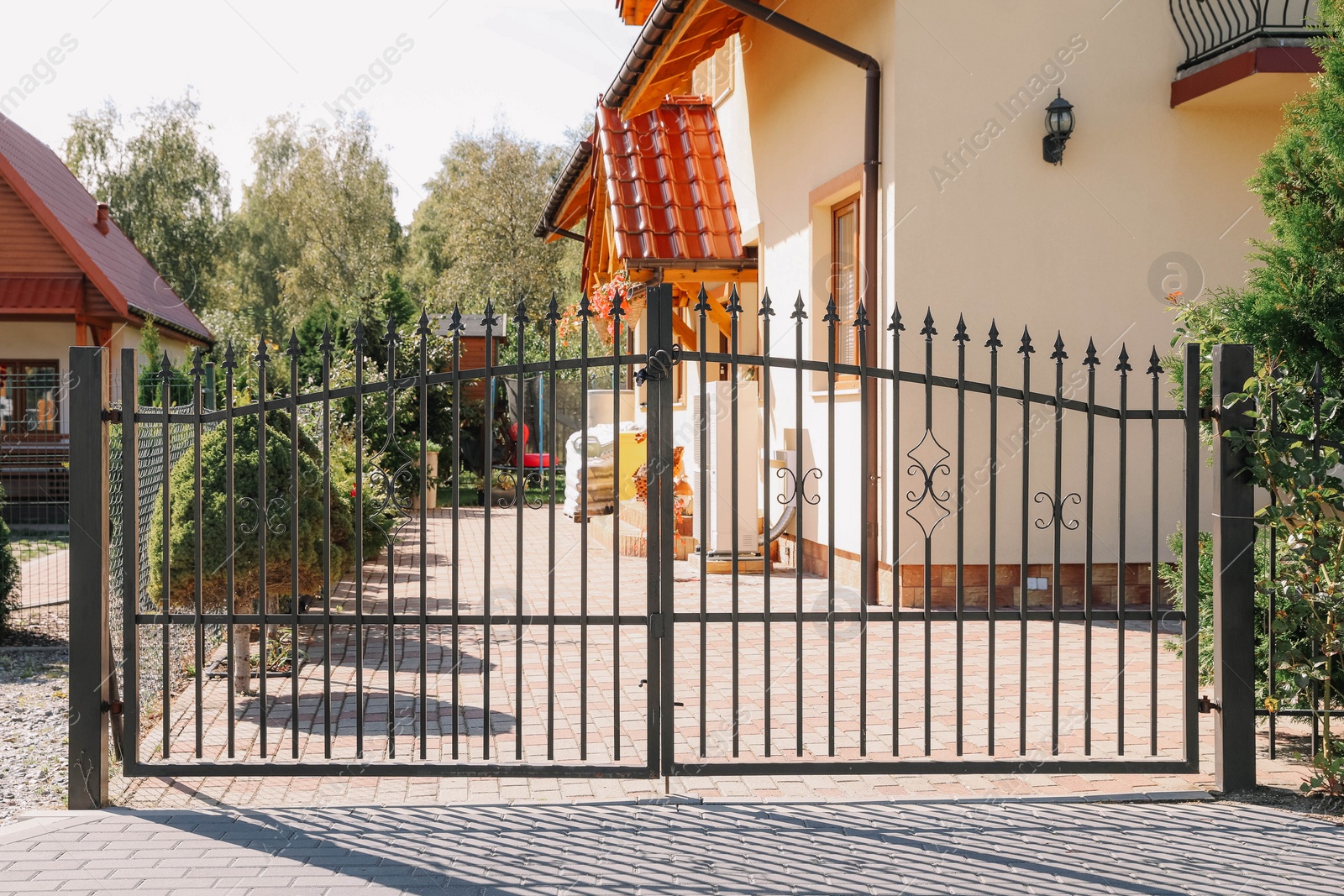 Photo of Closed metal gates near beautiful house on sunny day