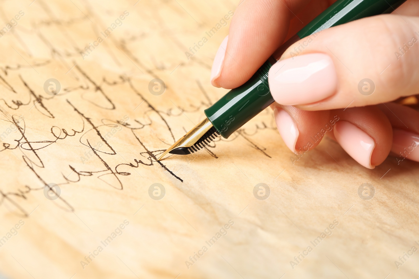 Photo of Woman writing letter with fountain pen, closeup