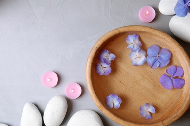 Photo of Flat lay composition with zen stones, spa bowl and space for text on grey background