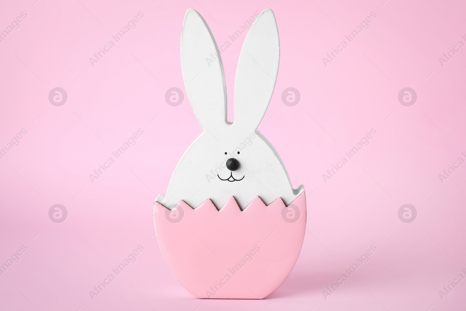 Photo of Bunny figure as Easter decor on pink background