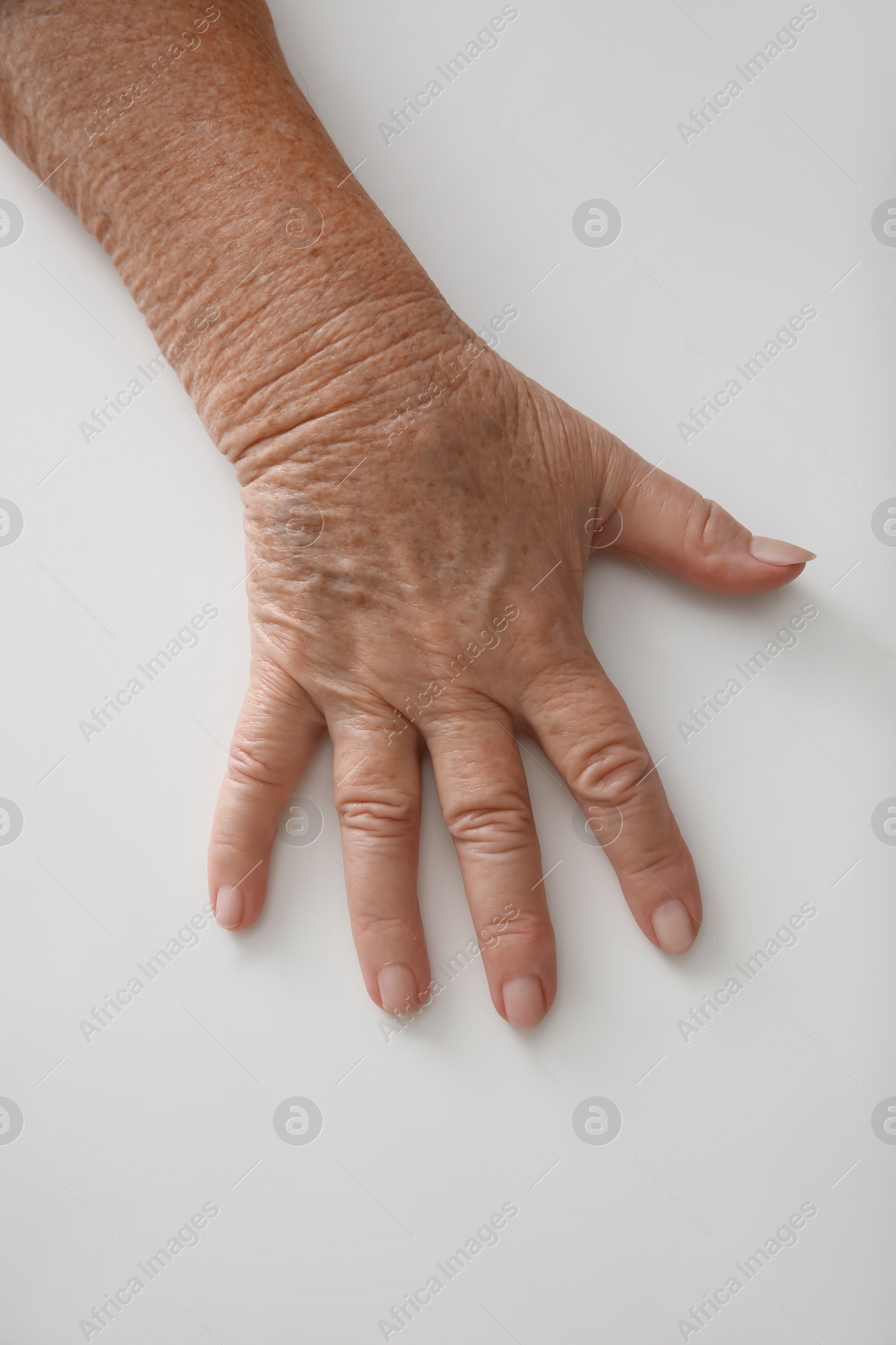 Photo of Top view of elderly woman at white table