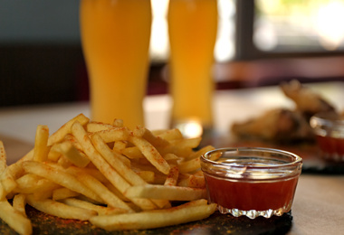 Delicious hot french fries with red sauce served on table