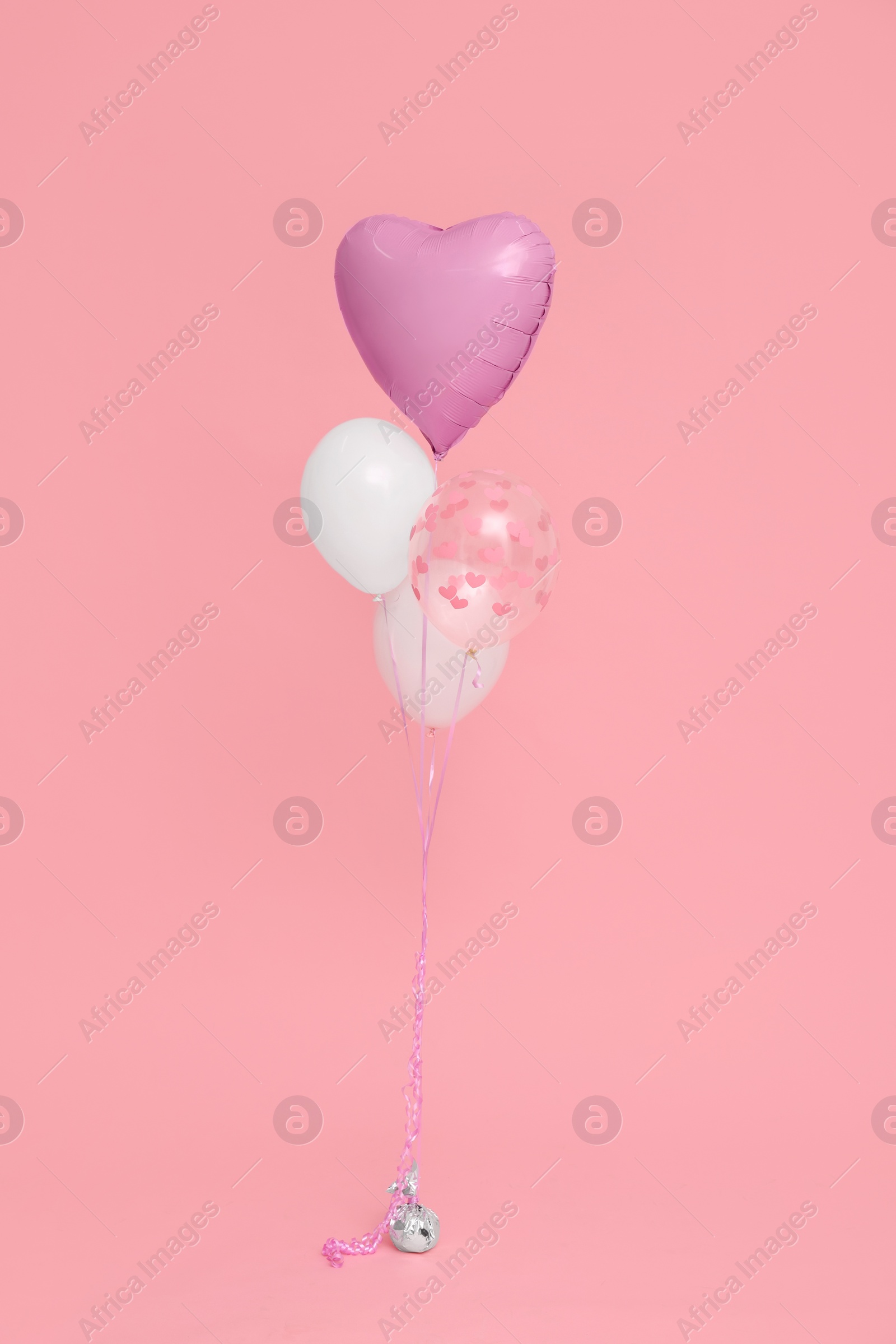 Photo of Bunch of heart and round shaped balloons for birthday party on pink background