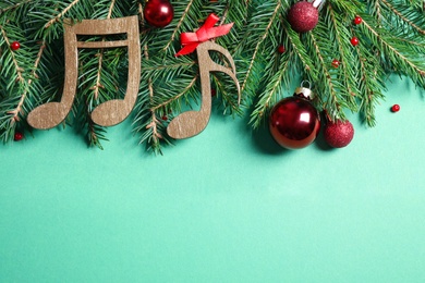 Photo of Flat lay composition with Christmas decor and music notes on light green background, space for text