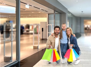 Happy family with shopping bags walking in mall