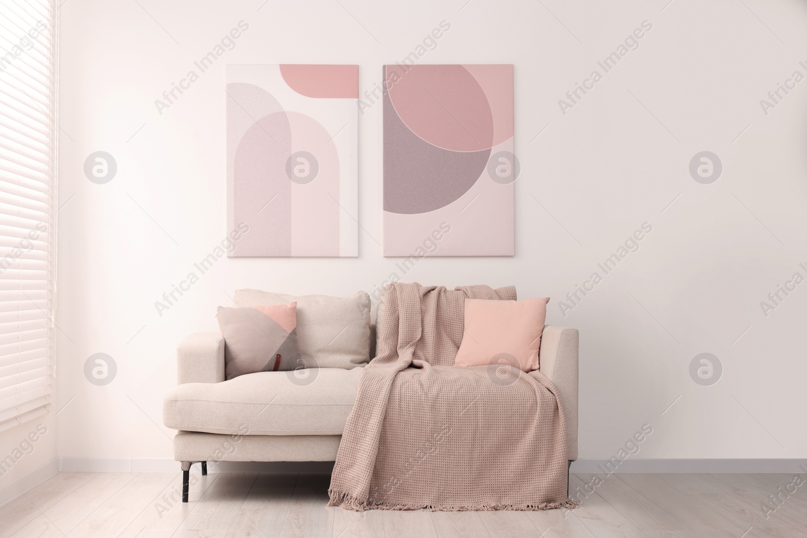 Photo of Cozy sofa with pillows and blanket in living room. Interior design