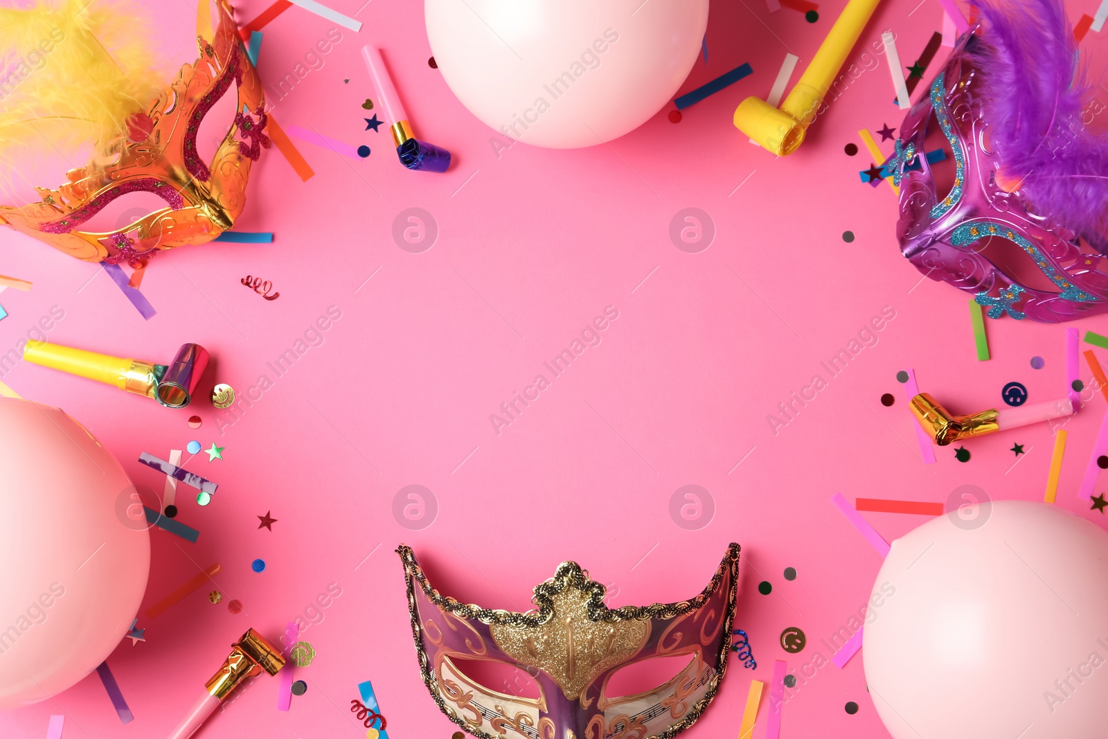 Photo of Frame of carnival masks and party decor on pink background, flat lay. Space for text
