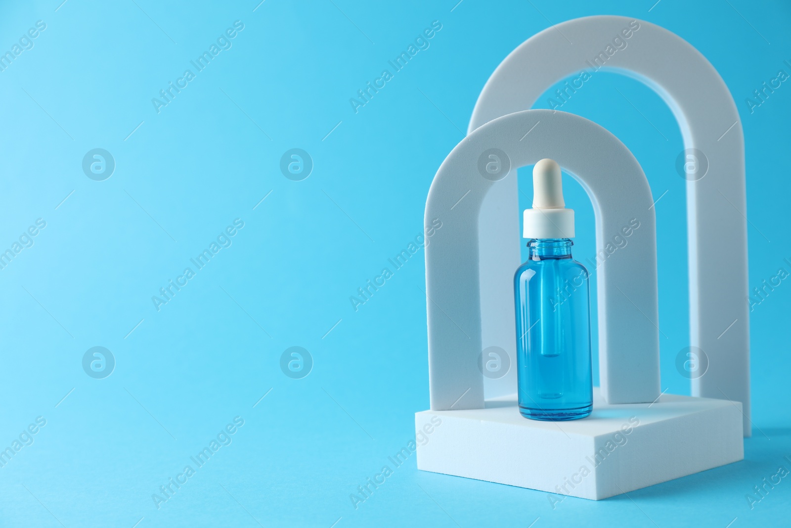 Photo of Stylish presentation of serum on light blue background. Space for text