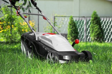 Photo of Lawn mower on green grass in garden