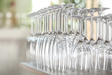 Photo of Empty glasses on wooden table against blurred background