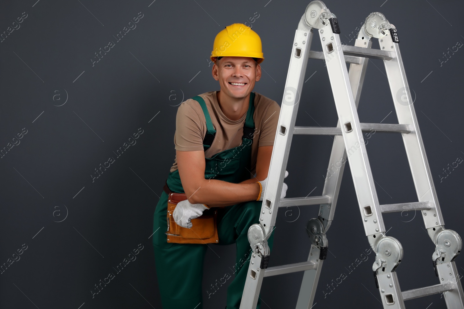 Photo of Professional constructor near ladder on black background