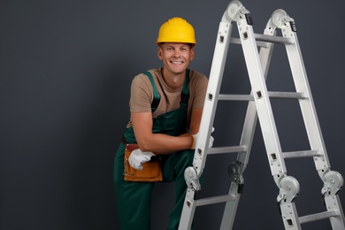 Photo of Professional constructor near ladder on black background