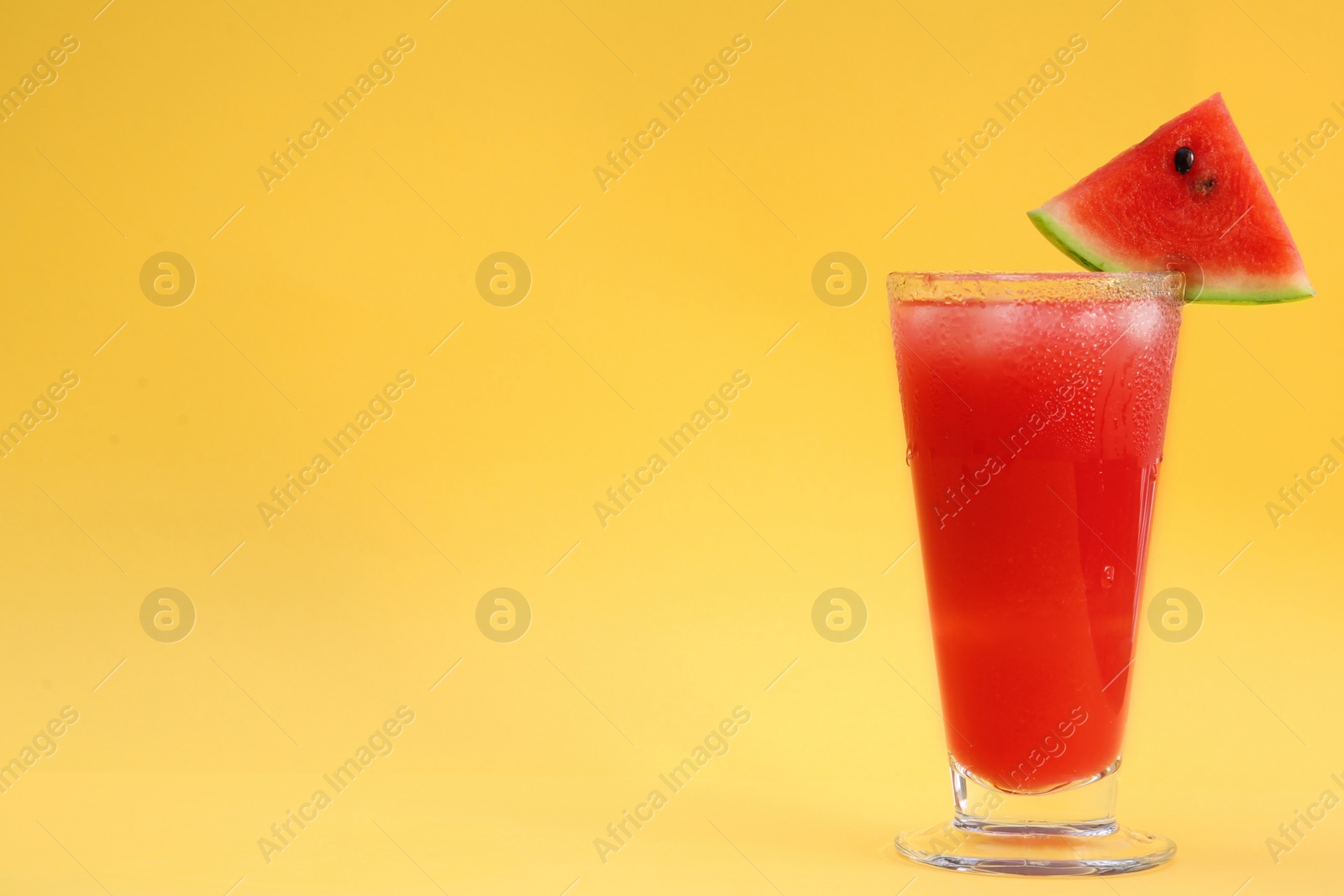 Photo of Delicious drink with piece of watermelon and ice cubes on yellow background, space for text