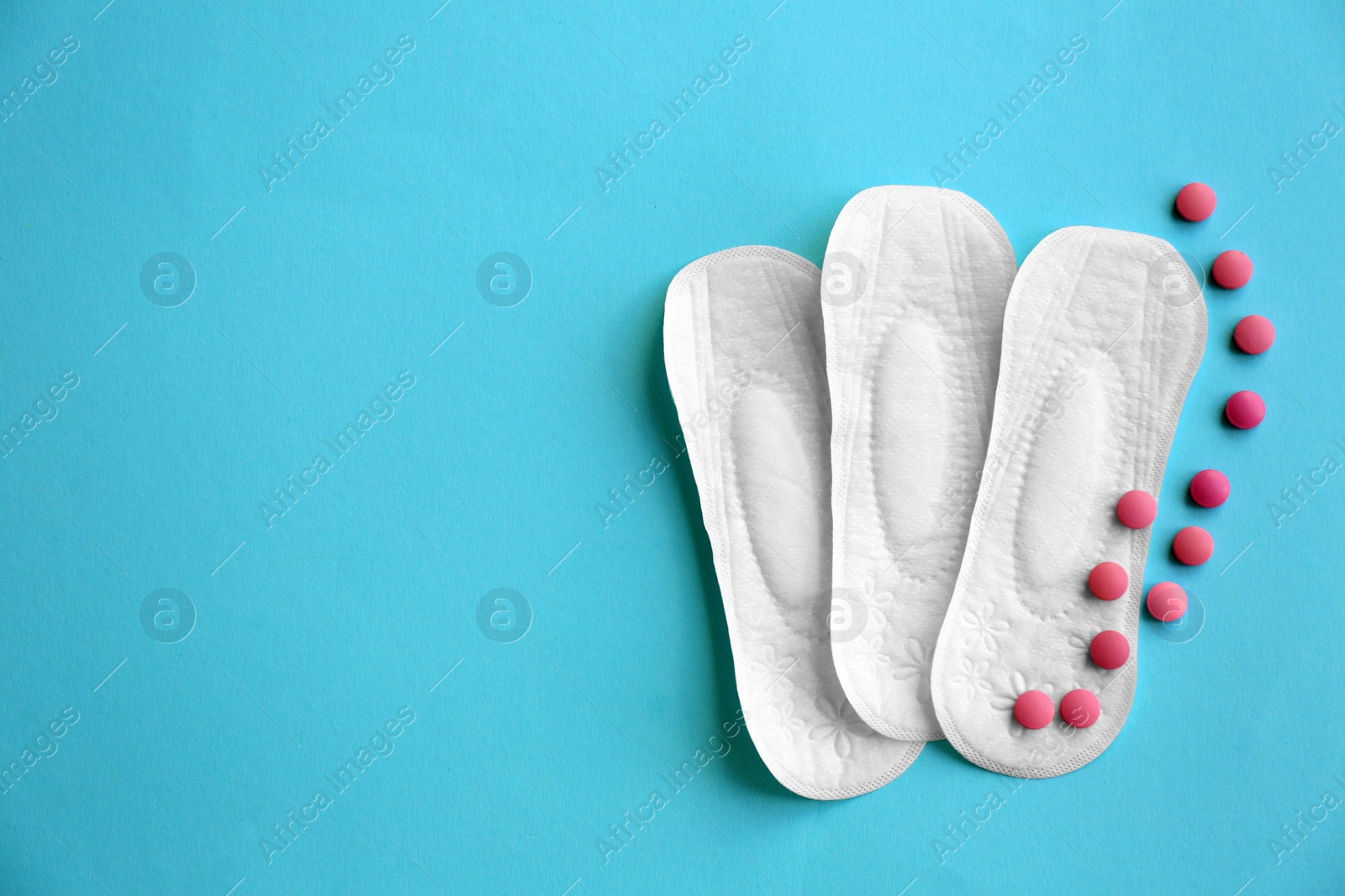 Photo of Flat lay composition with menstrual pads and pills on color background. Gynecological care