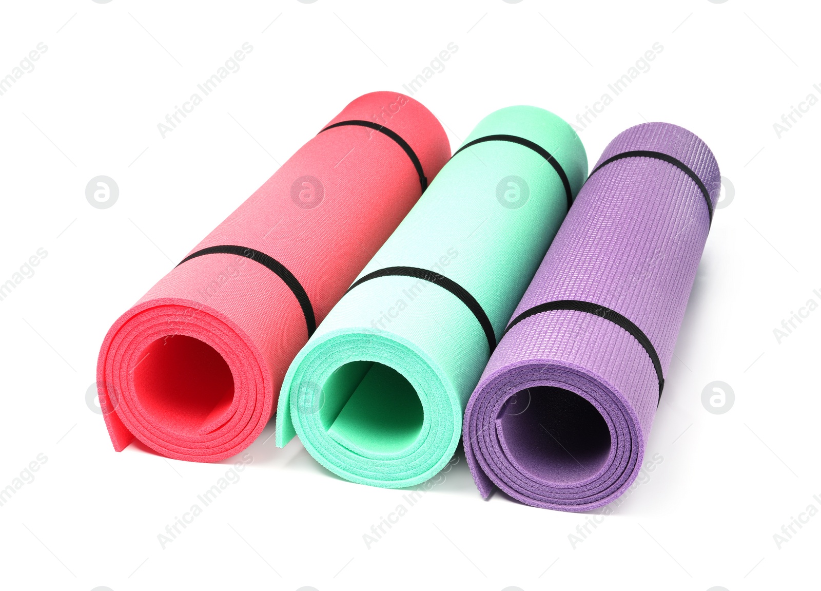 Photo of Colorful rolled camping or exercise mats on white background