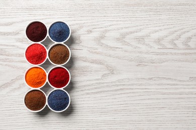 Photo of Many different food coloring on white wooden table, flat lay. Space for text