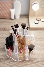 Photo of Organizer with cosmetic products for makeup on table