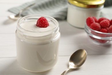 Photo of Bowl with delicious yogurt and raspberry on white wooden table, closeup