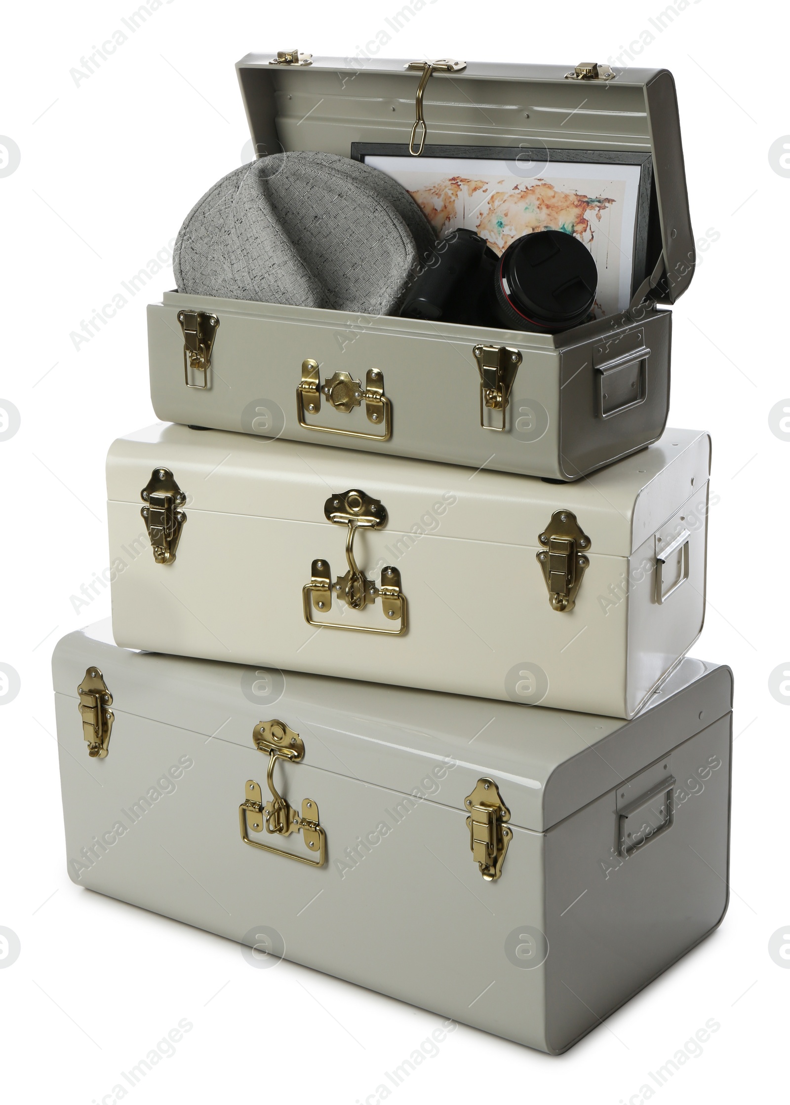 Photo of Stylish storage trunks with map, hat and camera on white background. Interior elements