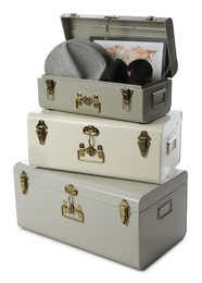 Photo of Stylish storage trunks with map, hat and camera on white background. Interior elements