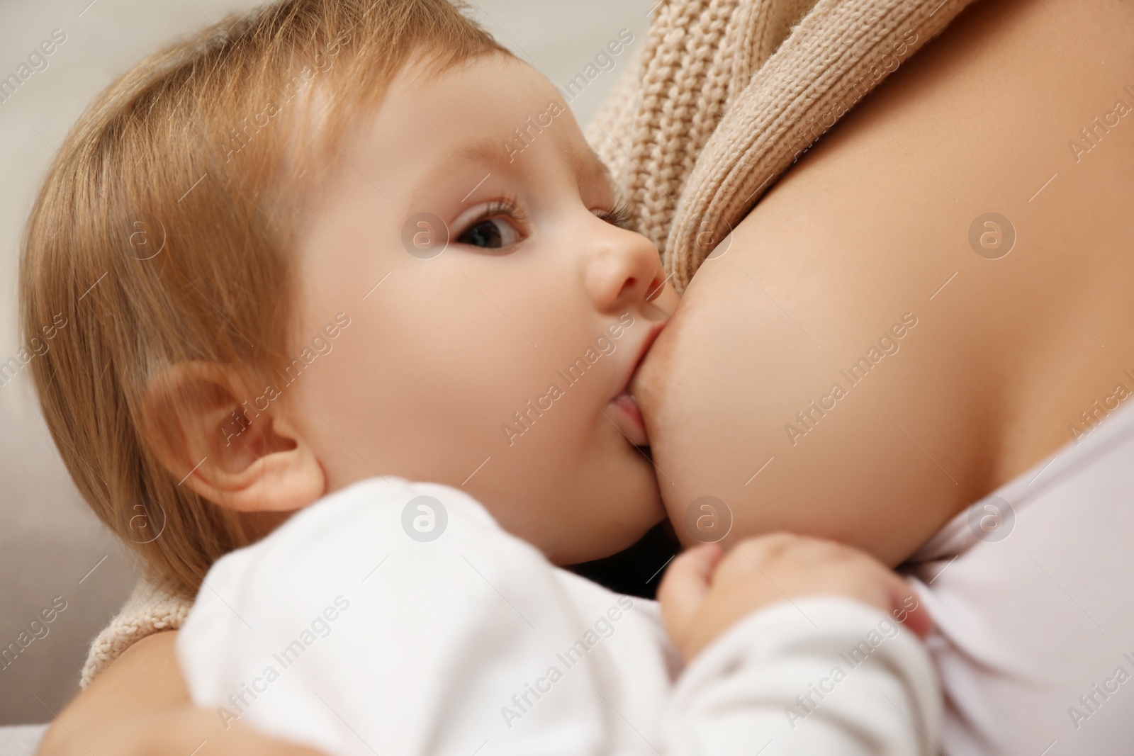 Photo of Woman breastfeeding her little baby, closeup view