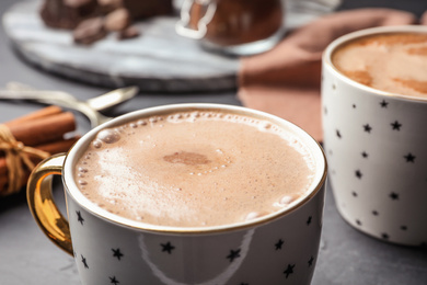 Cups of delicious hot cocoa on grey table, closeup