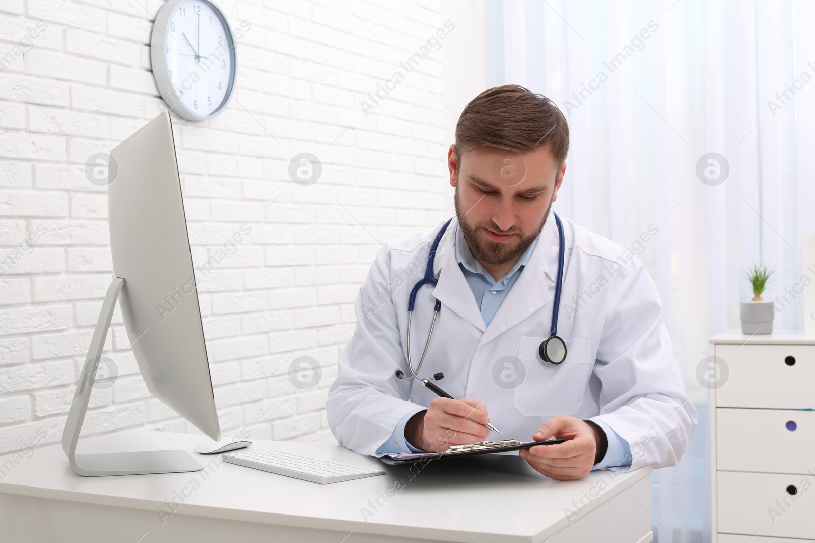 Photo of Young pediatrician working at table in clinic