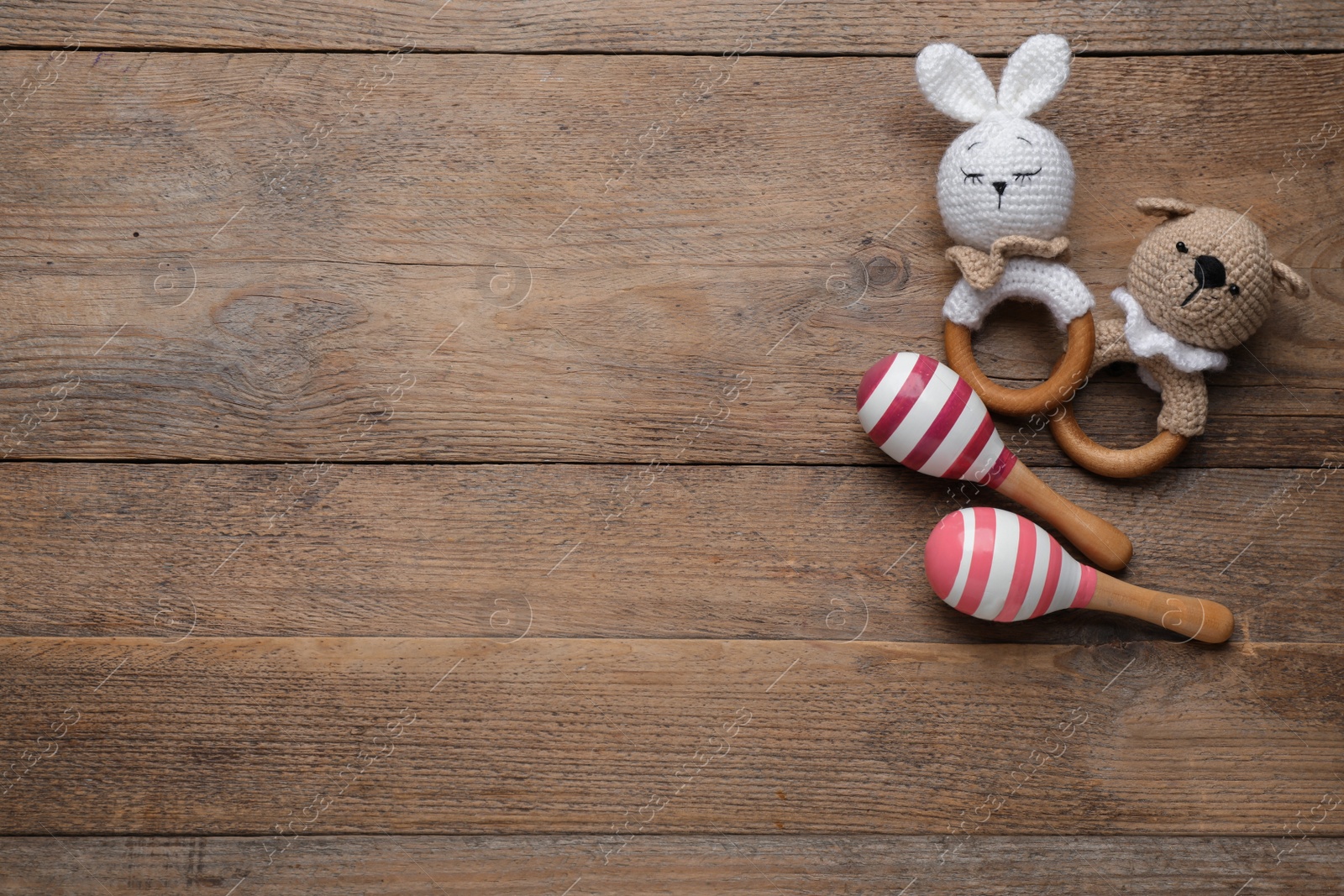 Photo of Cute baby toys on wooden background, flat lay. Space for text