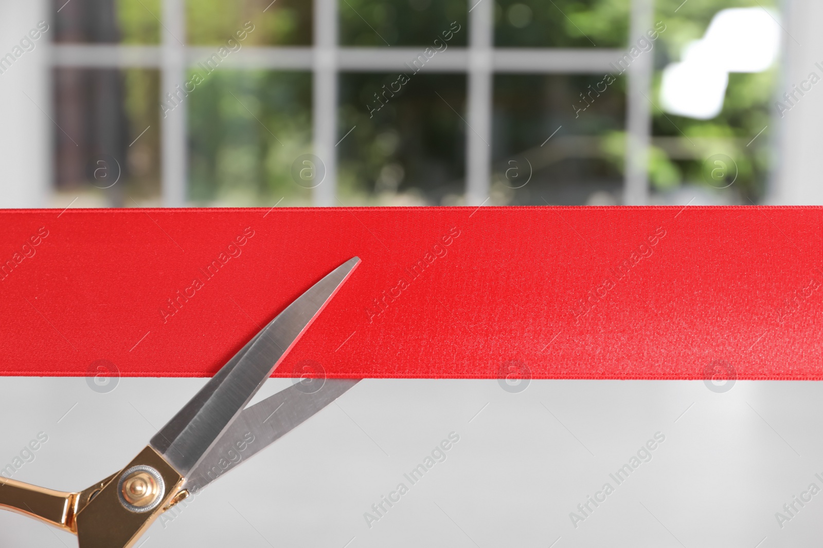 Photo of Ribbon and scissors on blurred background. Ceremonial red tape cutting