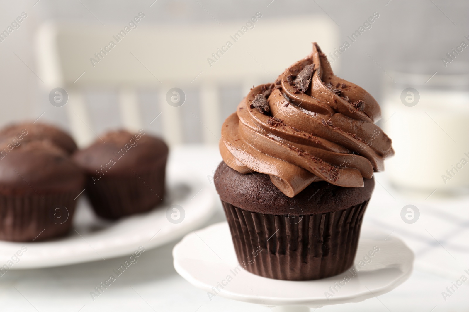 Photo of Delicious cupcake decorated with cream served on white table