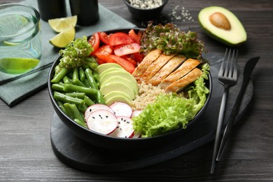 Photo of Healthy meal. Tasty products in bowl on black wooden table