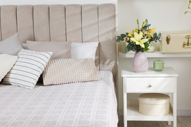 Photo of Bouquet of beautiful flowers on nightstand in bedroom