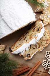 Photo of Traditional Christmas Stollen with icing sugar on wooden table, flat lay