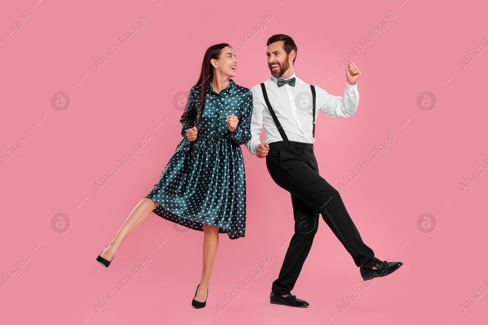 Photo of Happy couple dancing together on pink background