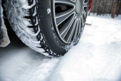 Car on snowy road, closeup. Space for text