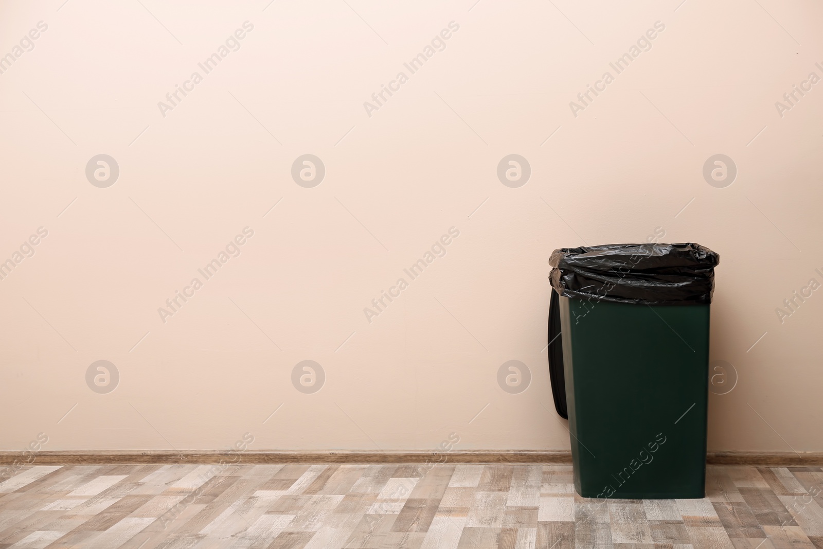 Photo of Trash bin near color wall indoors, space for text. Waste recycling