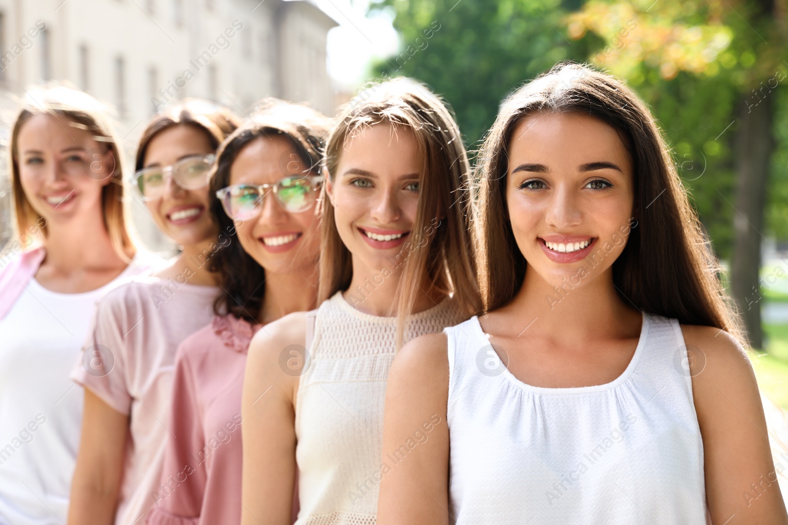 Photo of Happy women posing outdoors on sunny day. Girl power concept