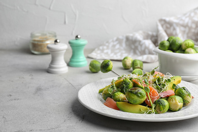 Photo of Tasty salad with Brussels sprouts on grey table/ Space for text
