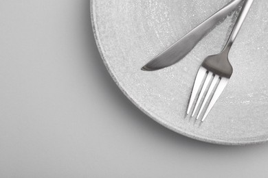 Photo of Setting with stylish cutlery on grey table, top view. Space for text
